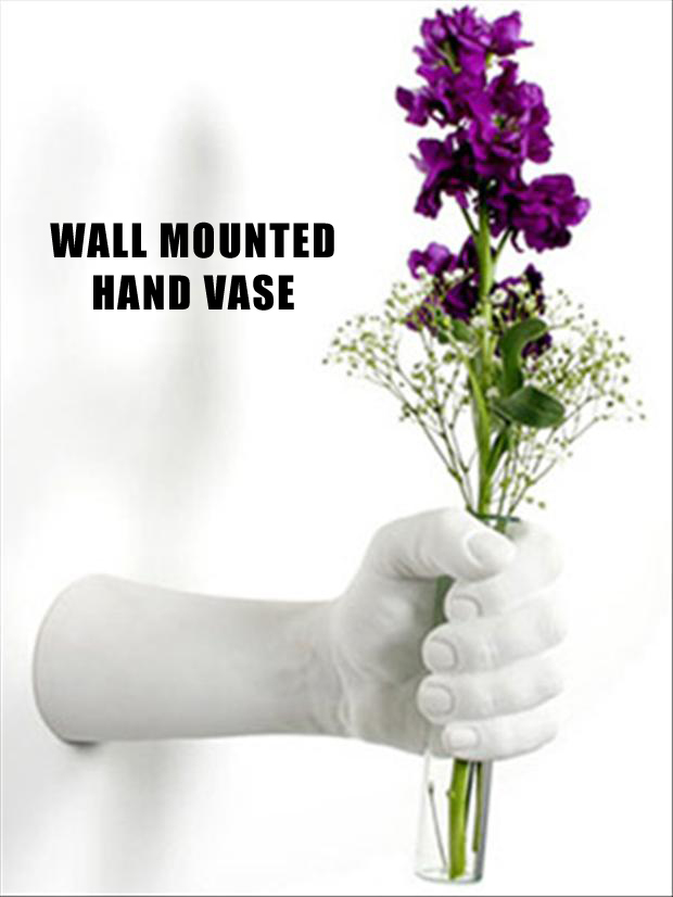 A creative vase that is wall mounted and is hand shaped