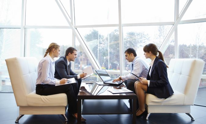 Photo of confident partners interacting at meeting in office