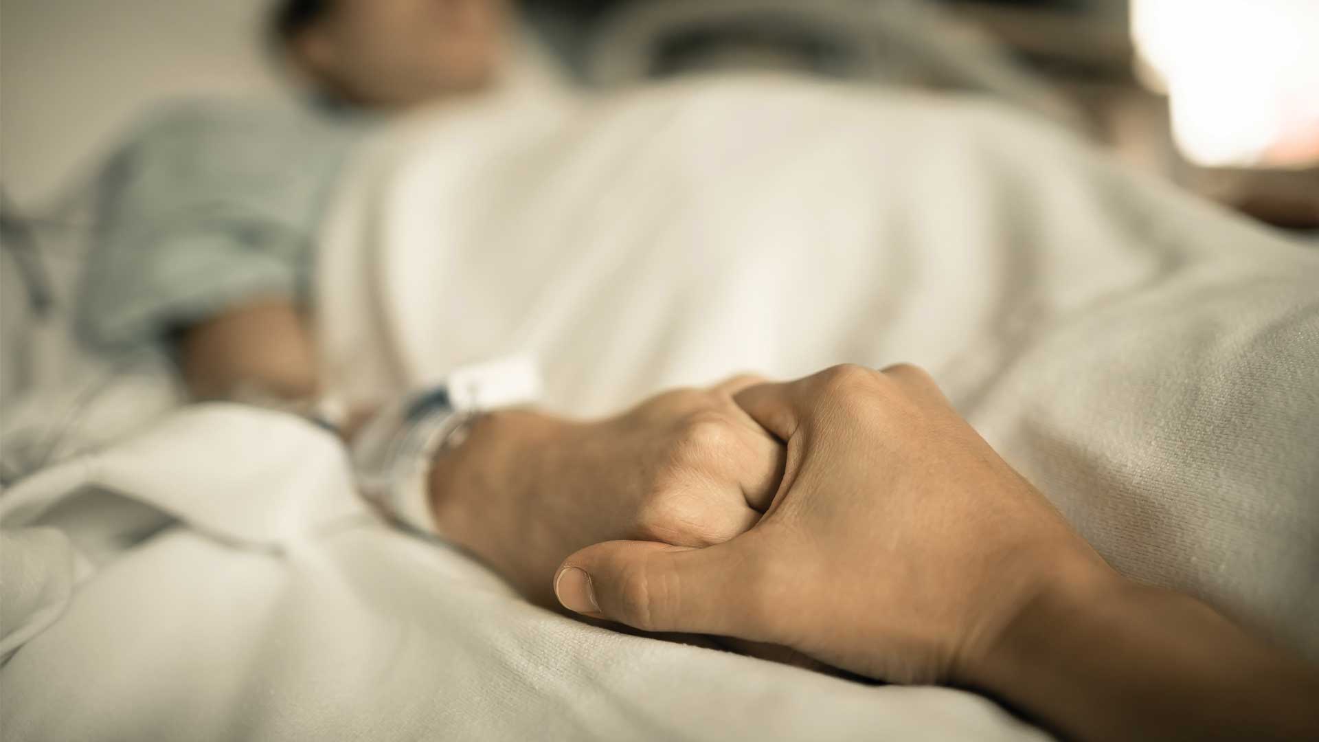 holding dying person's hand