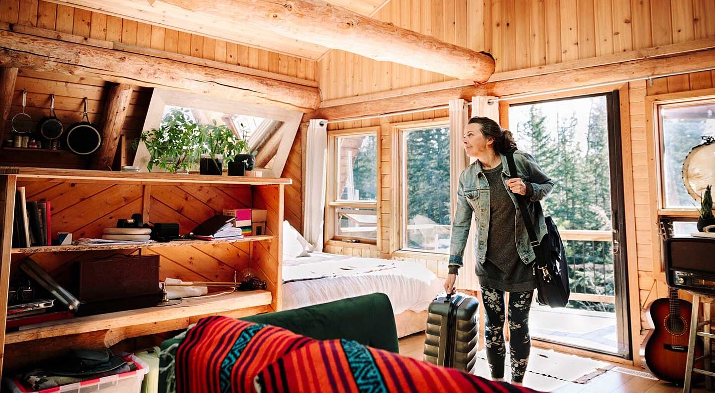 Woman with suitcase arriving at cabin